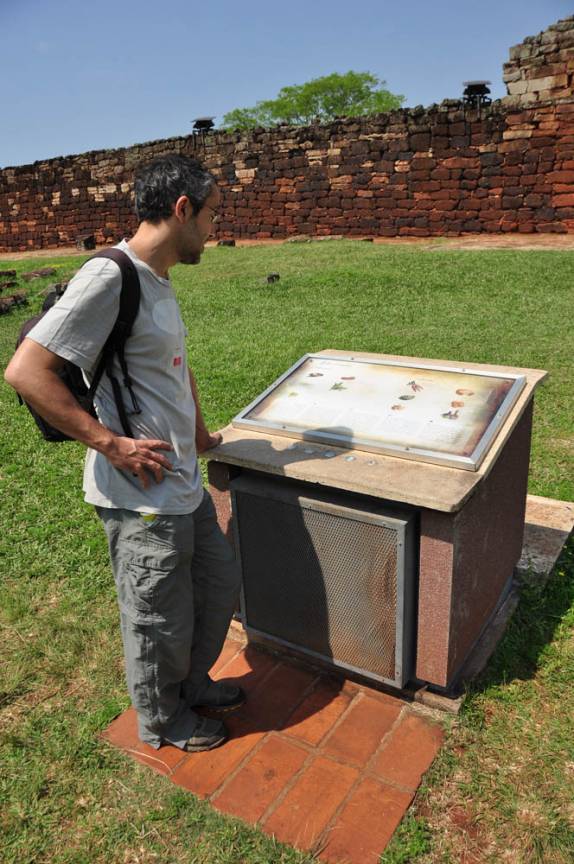 Lendo um dos muitos painéis informativos espalhados pelas ruínas de San Ignacio Mini, na Argentina